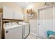 Bright laundry room equipped with a washer, dryer, and overhead cabinets for storage at 471 Henderson Lake Dr, Canton, GA 30115
