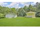 Large, grassy backyard with a shed, a white fence and a detached garage at 4911 Old Douglasville Rd, Lithia Springs, GA 30122