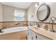 Bright bathroom features a soaking tub, vanity with bronze fixtures, and decorative tile accents at 4911 Old Douglasville Rd, Lithia Springs, GA 30122
