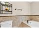 Neutral bathroom features a toilet, tiled walls and a built-in shelf with decorative items at 4911 Old Douglasville Rd, Lithia Springs, GA 30122