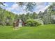 View of red barn and garage on landscaped green lawn at 4911 Old Douglasville Rd, Lithia Springs, GA 30122