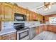 Open kitchen with wooden cabinets, tile floors, and stainless steel oven and dishwasher at 4911 Old Douglasville Rd, Lithia Springs, GA 30122