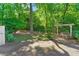 Secluded backyard oasis featuring a covered bench, mature plantings, and garden shed at 5 Windsor Ter, Avondale Estates, GA 30002