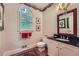 Elegant half bathroom with patterned wallpaper, marble sink, and decorative mirror at 8470 Valemont Dr, Atlanta, GA 30350