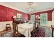 Formal dining room with elegant chandelier, red patterned wallpaper, and classic furnishings at 8470 Valemont Dr, Atlanta, GA 30350