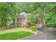Elegant brick home featuring an attached garage, lush landscaping, and a pristine lawn at 8470 Valemont Dr, Atlanta, GA 30350