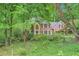 Charming two-story brick home with lush landscaping and mature trees offering privacy at 8470 Valemont Dr, Atlanta, GA 30350