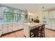 Bright kitchen featuring white cabinetry, marble countertops, a central island, and large windows overlooking the backyard at 8470 Valemont Dr, Atlanta, GA 30350