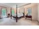 Bright main bedroom featuring a four-poster bed, tray ceiling, and large windows at 8470 Valemont Dr, Atlanta, GA 30350
