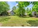 Spacious backyard featuring a large grassy area, mature trees, and partial fencing at 143 Frances Dr, Dallas, GA 30157