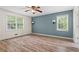 Spacious bedroom with hardwood floors, a ceiling fan, and two windows bringing in natural light at 143 Frances Dr, Dallas, GA 30157