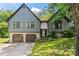 Charming exterior of gray home featuring brick accents, two-car garage, and well-maintained lawn at 143 Frances Dr, Dallas, GA 30157