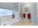 Bright bathroom featuring a soaking tub under a window and a separate walk-in shower with blue painted walls at 239 Taylors Farm Drive Dr, Canton, GA 30115