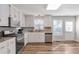 Open kitchen with white cabinets, stainless steel appliances, and wood-look floors at 239 Taylors Farm Drive Dr, Canton, GA 30115
