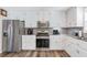 Kitchen featuring stainless steel appliances, white cabinetry, and wood-look flooring at 239 Taylors Farm Drive Dr, Canton, GA 30115