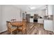 Kitchen with white cabinets, stainless steel appliances, wood-look floors, and an adjacent dining area at 239 Taylors Farm Drive Dr, Canton, GA 30115
