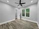 Bedroom with wood-style floors, ceiling fan, and natural light from the windows and a walk-in closet at 244 Coastline Road Rd, Fayetteville, GA 30214