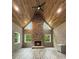 Cozy living room with hardwood floors, exposed brick, a stone fireplace and wood-paneled ceiling at 244 Coastline Road Rd, Fayetteville, GA 30214