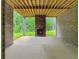 Covered patio with a stone fireplace and views of the trees and backyard at 244 Coastline Road Rd, Fayetteville, GA 30214