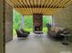 Covered patio featuring a stone fireplace and comfortable seating overlooking a lush green yard with mature trees at 244 Coastline Road Rd, Fayetteville, GA 30214