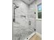 Updated shower featuring a glass door, marble tiling, and gray stone shower floor at 244 Coastline Road Rd, Fayetteville, GA 30214