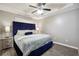 Beautifully staged bedroom featuring a blue accent headboard, modern ceiling fan, and neutral colored walls at 11529 Vinea Ln, Hampton, GA 30228