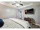 Comfortable bedroom featuring a mounted television, electric fireplace, and an open door to the hallway at 11529 Vinea Ln, Hampton, GA 30228