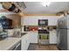 Bright kitchen featuring white cabinets, stainless steel appliances, and a convenient pot rack at 220 Renaissance Ne Pkwy # 1115, Atlanta, GA 30308
