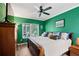 Green main bedroom with hardwood flooring, ceiling fan, and a large window at 220 Renaissance Ne Pkwy # 1115, Atlanta, GA 30308