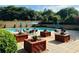 Community swimming pool area with tables, chairs, umbrellas and beautiful plants at 220 Renaissance Ne Pkwy # 1115, Atlanta, GA 30308