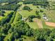 Aerial shot showcasing a home with mature trees and open land including outbuildings with horse enclosures at 226 Euharlee Five Forks Rd, Kingston, GA 30145