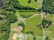 An aerial view showcasing a home with a long driveway on land with mature trees and open fields at 226 Euharlee Five Forks Rd, Kingston, GA 30145