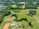 An aerial view highlighting a home with a long driveway, surrounded by lush greenery and open fields at 226 Euharlee Five Forks Rd, Kingston, GA 30145