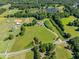 An aerial shot showcasing multiple water features with mature trees, open fields, and horse enclosures at 226 Euharlee Five Forks Rd, Kingston, GA 30145
