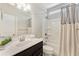 Clean bathroom featuring a vanity with dark wood cabinets and a shower-tub combination with grey and white curtains at 242 Aspen Way, Dallas, GA 30157