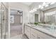 Bathroom featuring double sinks, granite countertops, tiled shower, and access to the main bedroom at 242 Aspen Way, Dallas, GA 30157