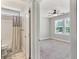 The en-suite bathroom with tub-shower combo is connected to a bedroom with carpet flooring and a ceiling fan at 242 Aspen Way, Dallas, GA 30157