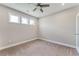 Cozy bedroom with neutral carpet and three windows offering lots of light plus a ceiling fan for ventilation at 242 Aspen Way, Dallas, GA 30157