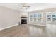 Bright living room with fireplace, hardwood floors, and many windows overlooking the front yard at 242 Aspen Way, Dallas, GA 30157