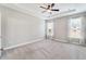 Spacious main bedroom featuring neutral carpet, ceiling fan, and tray ceiling with abundant natural light at 242 Aspen Way, Dallas, GA 30157