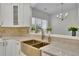 Bright kitchen features white cabinetry, gold hardware, marble countertops, and stainless appliances at 314 Santa Anita Ave, Woodstock, GA 30189
