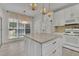 Bright kitchen features white cabinetry, gold hardware, marble countertops, and decorative light fixtures at 314 Santa Anita Ave, Woodstock, GA 30189
