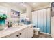Well-lit bathroom featuring a modern vanity, decorative mirror, and blue decorative shower curtain at 4406 Richmond Court Ct, Stone Mountain, GA 30083