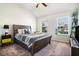 Cozy bedroom with a wood frame bed, plush carpet, and abundant natural light from two windows at 4406 Richmond Court Ct, Stone Mountain, GA 30083