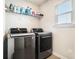 Modern laundry room with gray front-load washer and dryer set and ample shelving at 4406 Richmond Court Ct, Stone Mountain, GA 30083