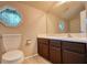 Bathroom features a white toilet and sink with a dark vanity and a octagonal window for natural light at 924 Park Gate Pl, Stone Mountain, GA 30083
