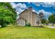 A charming tan two-story home with a spacious lawn, a chimney, and a sunroom at 924 Park Gate Pl, Stone Mountain, GA 30083
