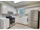 Modern kitchen with white cabinets, stainless steel appliances, granite countertops and gray backsplash at 924 Park Gate Pl, Stone Mountain, GA 30083