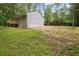 View of home featuring a wooden deck overlooking the spacious, grassy backyard, surrounded by mature trees and nature at 2160 Perkerson Sw Rd, Atlanta, GA 30315