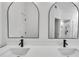 Close up on bathroom featuring double sinks, modern matte black faucets and hardware, and arched mirrors at 2601 Garland Way, Duluth, GA 30096